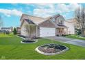Well-manicured lawn and landscaping highlight this inviting two-story home's exterior at 7115 N Lyndhurst Xing, McCordsville, IN 46055