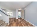 Bright living room with hardwood floors, staircase, and open front door at 7115 N Lyndhurst Xing, McCordsville, IN 46055