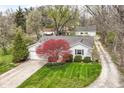 Aerial view of a single-story home with a well-manicured lawn, mature trees, and a driveway at 7145 Lafayette Rd, Indianapolis, IN 46278