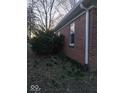 Side view of brick home showcasing lush foliage, brickwork, and gutter system at 721 1St Ne Ave, Carmel, IN 46032