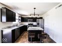 Modern kitchen with black cabinets, stainless steel appliances, marble countertops and a central island with seating at 729 Stonehenge Way, Brownsburg, IN 46112