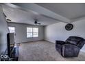 Cozy living room featuring a large window, neutral carpet, and a comfortable armchair, creating a welcoming atmosphere at 729 Stonehenge Way, Brownsburg, IN 46112