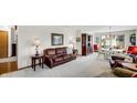 Cozy living room with plush brown leather seating, neutral walls and carpet, and traditional wood furniture at 803 S School St, Brownsburg, IN 46112