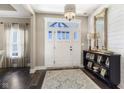 Inviting foyer with elegant light fixture, a large mirror, and a decorative console table at 978 S Fairway Village Ct, Greenfield, IN 46140