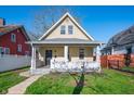 Charming two-story home featuring a gabled roof and inviting front porch framed by a well-manicured lawn under blue sky at 106 N Linwood Ave, Indianapolis, IN 46201