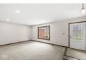 Bright living room featuring neutral carpet, a window, and a door with decorative glass at 1132 Sheffield Dr, Avon, IN 46123