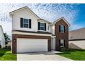 Charming two-story home with attached garage, showcasing a well-maintained lawn and inviting curb appeal at 11629 Brookwood Trace Ln, Indianapolis, IN 46229