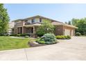 Two story brick home with manicured landscaping, a circular driveway, and an attached two-car garage at 13225 Gatman Ct, Carmel, IN 46032