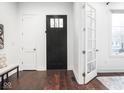 Beautiful entryway with a black front door, white trim and hardwood flooring at 1326 E 10Th St, Indianapolis, IN 46202
