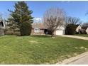 Lovely single-story brick home with a well-manicured lawn, mature trees, and an attached two-car garage at 1348 Secretariat Ln, Indianapolis, IN 46217