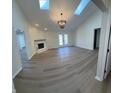 Spacious living room with vaulted ceilings, skylights, fireplace, and access to the backyard through french doors at 1348 Secretariat Ln, Indianapolis, IN 46217