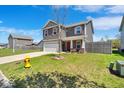 Two-story home featuring gray siding, red shutters, two-car garage, and well-kept lawn at 159 Longleaf Ln, Greenfield, IN 46140