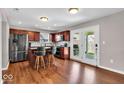 Modern kitchen features stainless steel appliances, island with seating, and wood floors at 159 Longleaf Ln, Greenfield, IN 46140