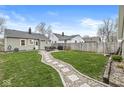Large backyard with a stone path, grassy areas, and fencing, ideal for outdoor enjoyment at 1741 Caldwell Pl, Columbus, IN 47201