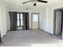 Bright living room with new carpet, neutral walls, ceiling fan and large windows, creating an inviting atmosphere at 1804 W 15Th St, Muncie, IN 47302