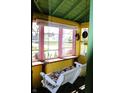 Cozy porch with swing, pink framed windows, and natural lighting at 2025 Barth Ave, Indianapolis, IN 46203