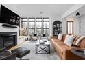 Bright living room featuring large windows, a modern fireplace, sleek furnishings, and hardwood floors at 2134 N New Jersey St, Indianapolis, IN 46202