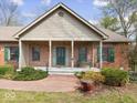 Inviting front porch with a brick facade, green shutters, and a cozy bench offering curb appeal at 2810 Winterway Dr, Shelbyville, IN 46176