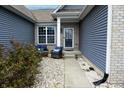 Inviting front porch seating area with comfortable blue chairs, perfect for relaxing outdoors at 2890 Trillium Way, Columbus, IN 47201