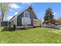 Attractive home exterior showcasing a neatly kept lawn, siding, and detached garage and carport at 3015 S Rybolt Ave, Indianapolis, IN 46241