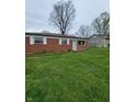 Single-story home featuring a classic brick facade and lush green lawn on a cloudy day at 314 S Taft Ave, Indianapolis, IN 46241