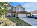 Traditional home with attached three-car garage, manicured lawn, and covered front entryway at 3529 Miesha Dr, Indianapolis, IN 46217