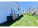 A deck and green grass in a spacious backyard with a partial view of a white house at 4064 Waterfield Dr, Indianapolis, IN 46235