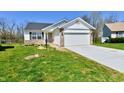 Charming single-story home featuring a two-car garage and a well-maintained lawn at 4064 Waterfield Dr, Indianapolis, IN 46235