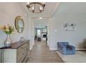 Inviting entryway featuring wood floors, a decorative mirror, modern lighting, and an open view to the living room at 4140 Omaha Dr, Bargersville, IN 46106