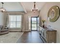 Inviting entryway with a decorative mirror, wood floors, modern chandelier, console table and a view into the front yard at 4140 Omaha Dr, Bargersville, IN 46106