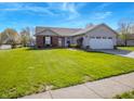 Well-maintained front yard with lush green grass and a charming brick and vinyl sided single story home at 498 Lake Shore Ct, Franklin, IN 46131