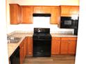 Kitchen with stainless steel appliances, wood cabinets, and tile backsplash at 5069 Lilium Dr, Plainfield, IN 46168