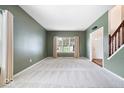 Spacious living room features neutral carpet, green walls, and large window bringing in light at 5343 Ripplingbrook Way, Carmel, IN 46033