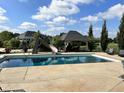 Backyard pool with slide, surrounded by lush landscaping and a covered outdoor lounge area, perfect for relaxation at 5373 Ashby Ct, Greenwood, IN 46143