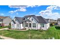 Beautiful home with black roof accents, crisp white siding, a manicured lawn, and beautiful landscaping at 5492 Cottage Grove Ln, Noblesville, IN 46062
