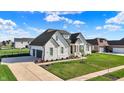 Beautiful home with black roof accents, crisp white siding, a manicured lawn, and an attached two car garage at 5492 Cottage Grove Ln, Noblesville, IN 46062