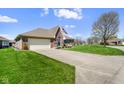 Attractive brick home with manicured lawn, an American flag, and a two-car garage at 5766 Kensington S Way, Plainfield, IN 46168