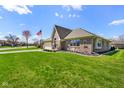 A beautiful brick home with manicured lawn, an American flag and lovely landscaping at 5766 Kensington S Way, Plainfield, IN 46168