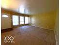 Bright living room featuring carpet, large windows, and a neutral color palette at 5868 Hillside Ave, Indianapolis, IN 46220