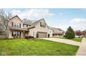 View of the home and its landscaped yard, featuring a two-car garage and driveway at 6526 Angel Falls Dr, Noblesville, IN 46062