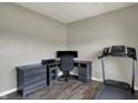 Home office setup with desk, monitors, printer, chair and treadmill near a window in a neutral color scheme at 6674 Buhrstone Ln, Avon, IN 46123