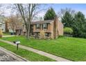 Charming home showcasing a manicured lawn, brick chimney, and a blend of siding textures for a classic look at 6853 Cordova Dr, Indianapolis, IN 46221