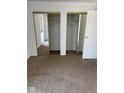 Carpeted bedroom features dual mirrored closets and a door to the exterior at 7411 Country Brook Dr, Indianapolis, IN 46260