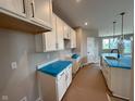 Modern kitchen with white cabinets, countertops, stainless steel sink, and pendant lighting at 7421 Broadview Ln, McCordsville, IN 46055