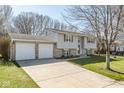 A split-level house with an attached two-car garage and a long driveway for convenient parking at 7624 Snowflake Dr, Indianapolis, IN 46227
