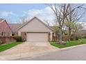 Charming brick home featuring an attached two-car garage and well-maintained landscaping at 8535 Olde Mill Circle West Dr, Indianapolis, IN 46260