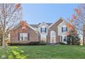 Beautiful two-story brick home with an arched entryway and manicured lawn, exuding curb appeal at 8965 Snowberry Ct, Zionsville, IN 46077