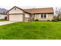Well-maintained home featuring lush green lawn, mature tree, and attached two car garage at 8973 Sunningdale Blvd, Indianapolis, IN 46234