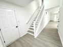 Bright entryway featuring a staircase with white railings and light wood-look flooring at 10200 Cheswick Ln, Fishers, IN 46037