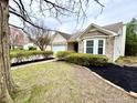 Attractive brick home boasting a beautiful bay window, neat landscaping, and a two-car garage at 10200 Cheswick Ln, Fishers, IN 46037